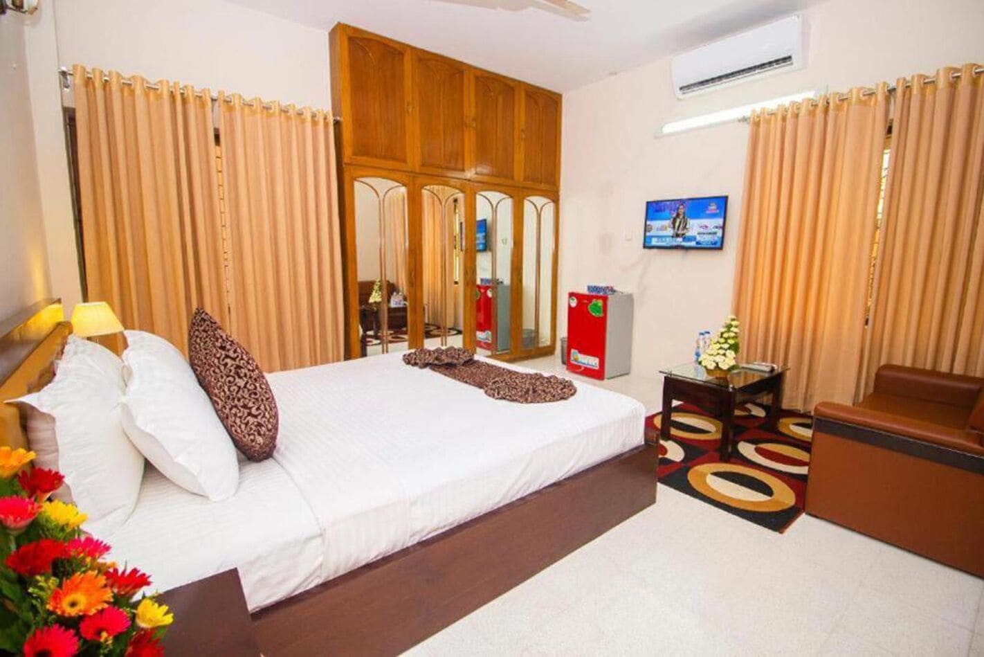 A hotel room with a bed, a television, a desk, and a chair.