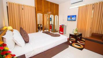 A hotel room with a bed, a television, a desk, and a chair.