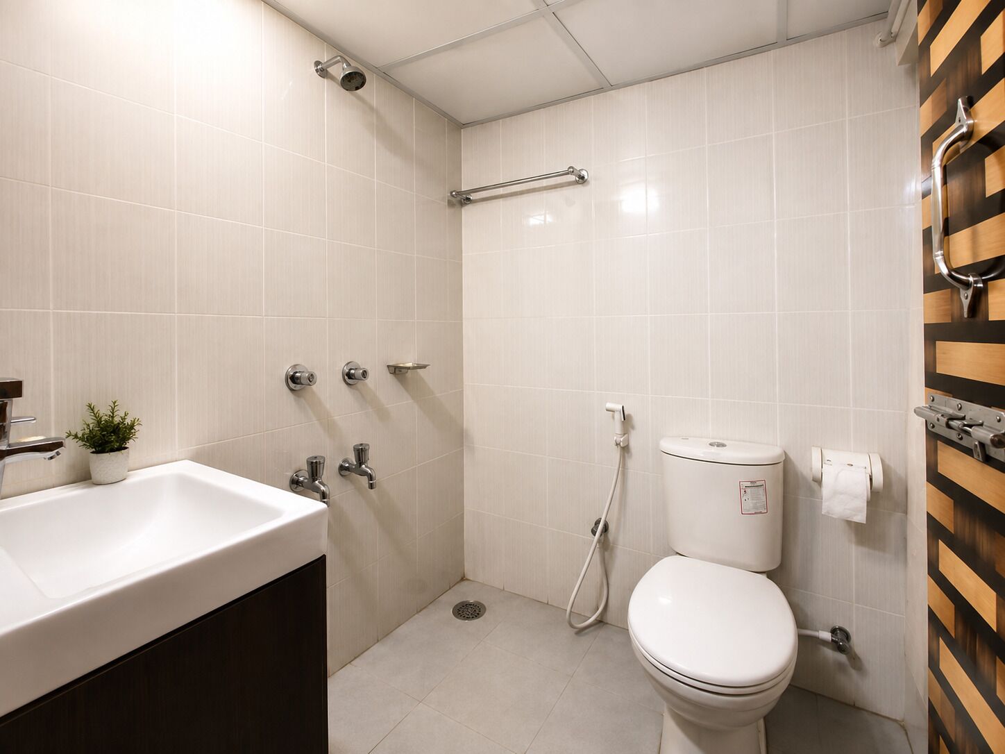 Un baño con lavamanos blanco, inodoro y zona de ducha.