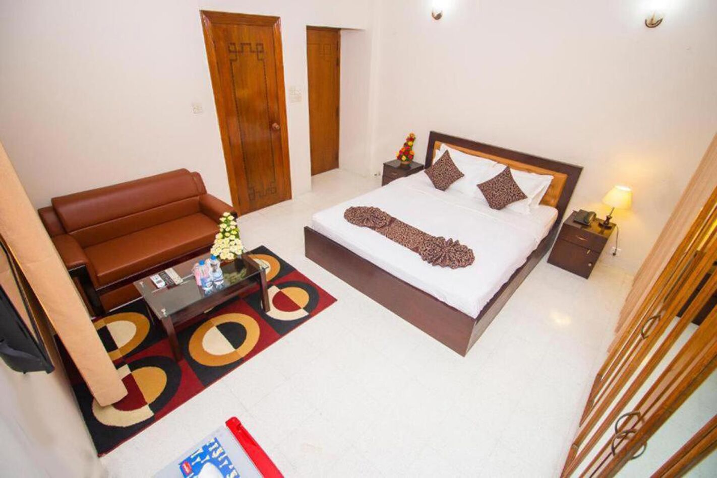 Una habitación de hotel con una cama, un sofá, una mesita de noche y una mesa de centro.