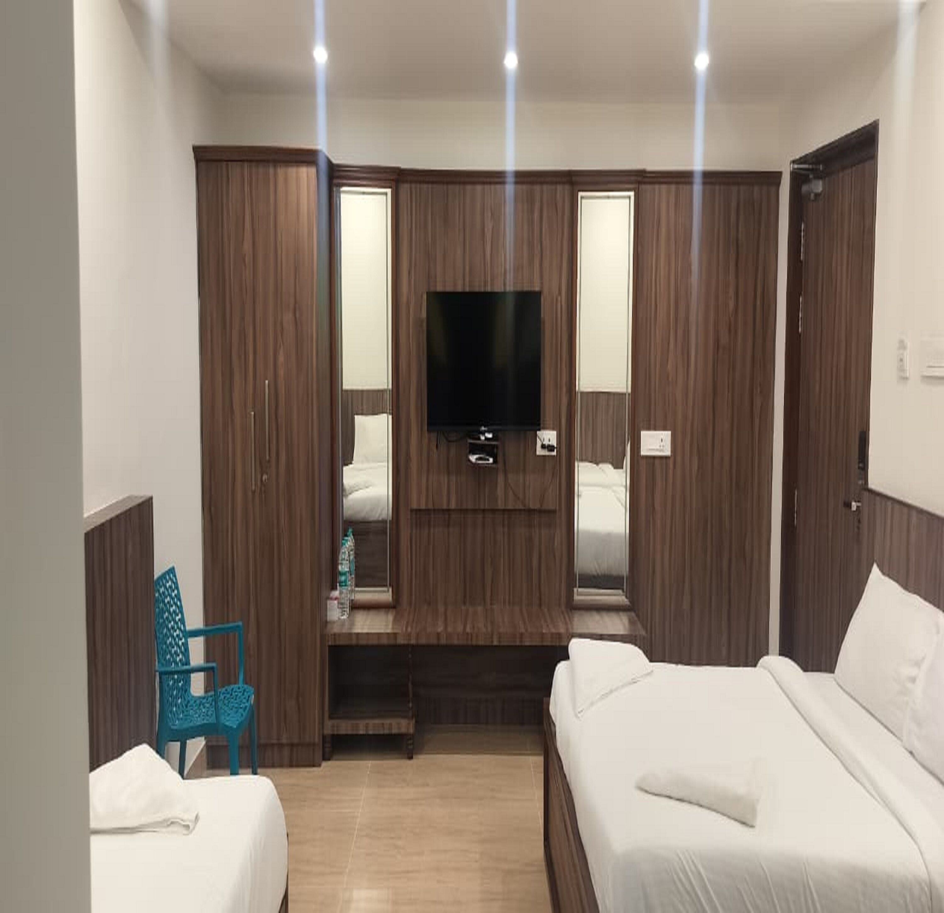 Una habitación de hotel con cama, televisión y armario.