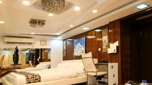 Una habitación de hotel moderna con una cama grande, un escritorio con una silla y una araña.