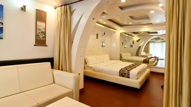 Habitación de hotel con sofá, cama doble y un espejo grande.