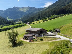 Eine ländliche Landschaft mit einer großen Scheune, einem kleineren Gebäude und einer gewundenen Straße.