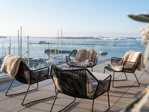 A terrace with outdoor seating and a view of the marina. - Guesthouse with terrace and beautiful views (Breitenbrunn)