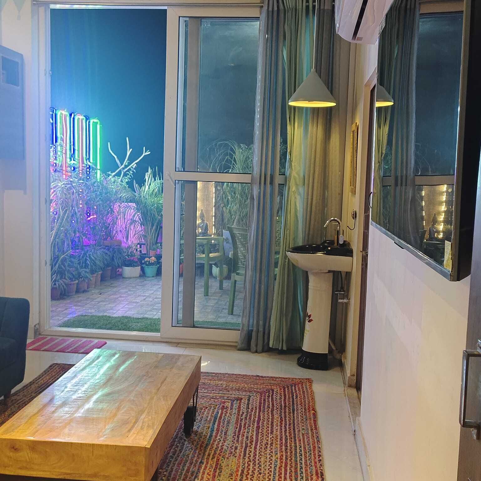 Uma sala de estar moderna com uma grande porta de vidro deslizante que dá para um pátio.