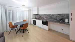 A compact kitchen with a marble countertop, a built-in dishwasher, and a coffee maker. - Imedio Coral Apartment Aviatiei (București)