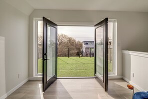 A room with a large sliding glass door leading to a grassy outdoor area.