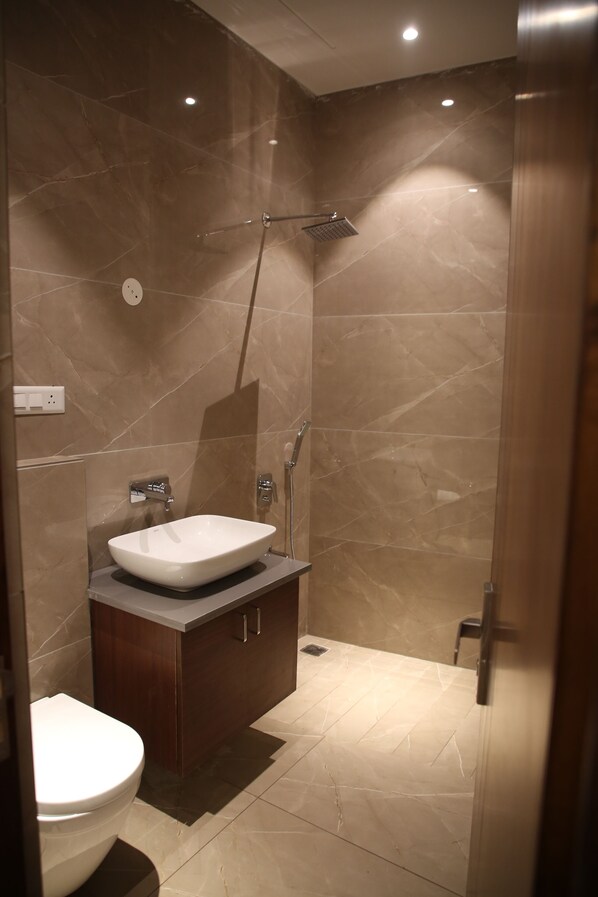 A modern bathroom with a marble sink, a shower, and a toilet. - Country Yard Hotel (Nakodar)