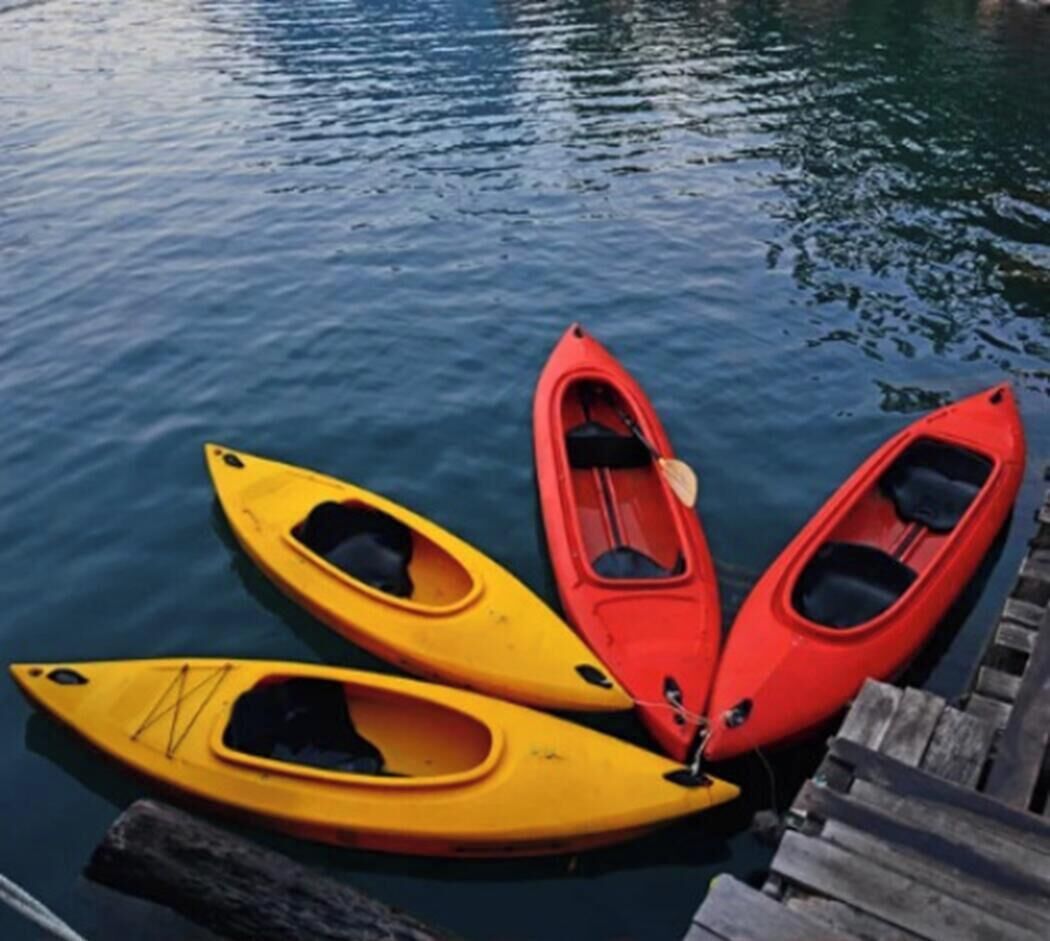 Tres kayaks amarrados a un muelle de madera.