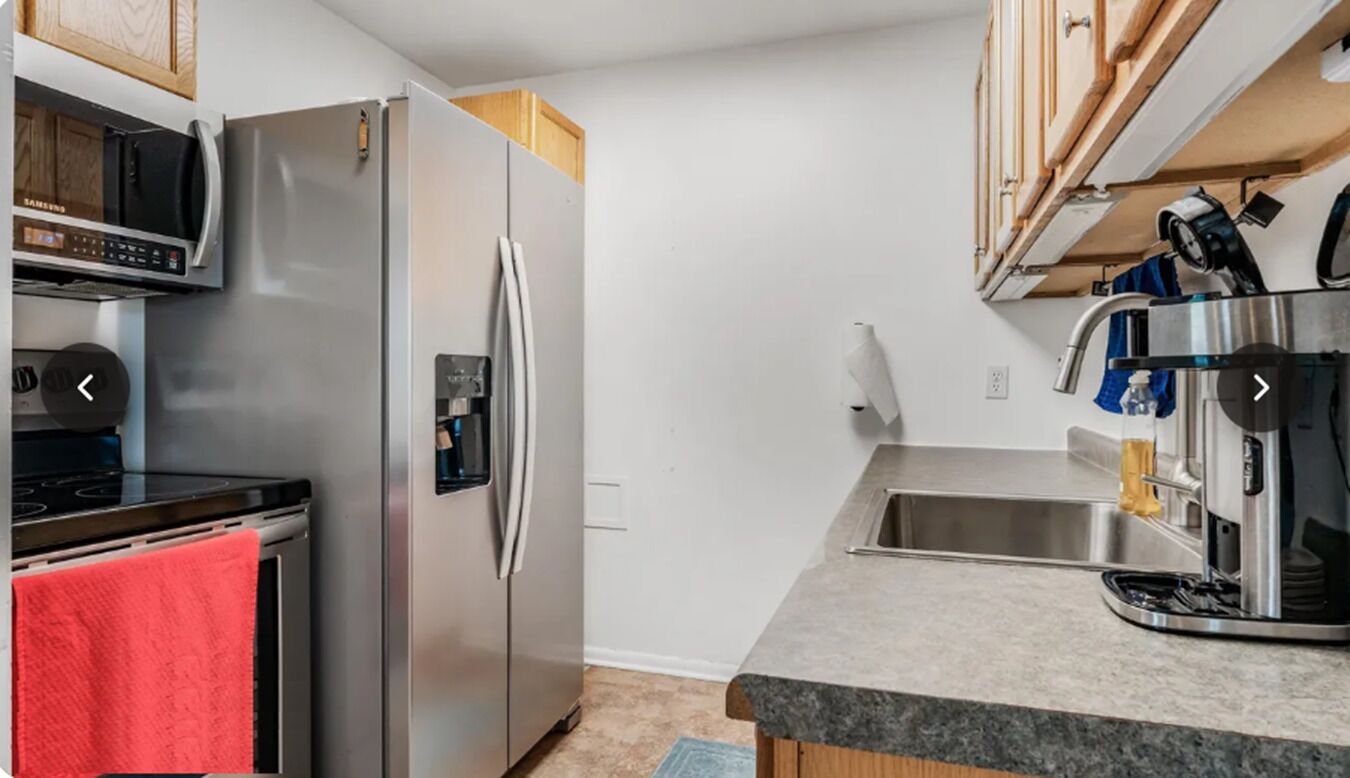 Una cocina moderna con un refrigerador de acero inoxidable, un microondas y una cafetera.