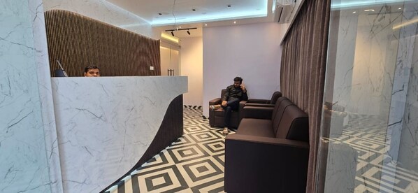 A modern lobby with marble flooring, a reception desk, and seating areas. - Hotel Ultimate One (Bhubaneshwar)