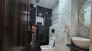 Une salle de bain moderne équipée de toilettes, d’un lavabo et d’une douche.