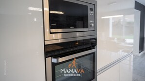 Una cocina con microondas y horno, una pantalla digital y un logotipo en la puerta del horno.