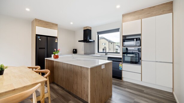 A modern kitchen with a central island, built-in appliances, and a view of the outside. - Full-sized 3 Bedroom Townhouse - Walking distance to Stadium (Christchurch)