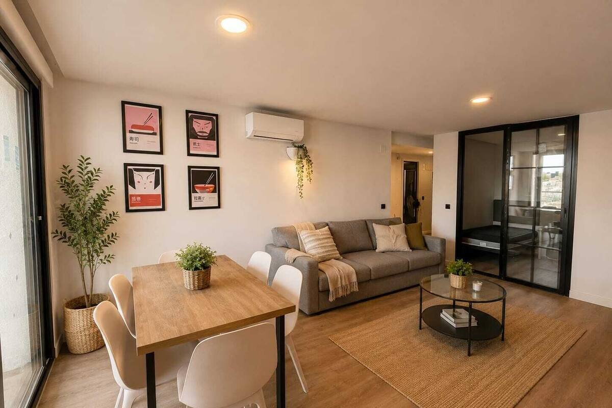 A modern living room with a sofa, a dining table with chairs, a coffee table, and a large window.