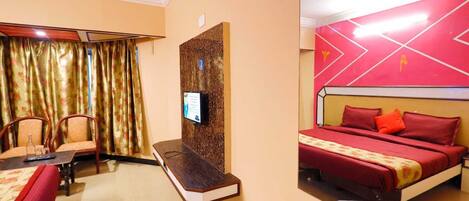 A hotel room with a bed, a desk, a chair, a television, and a curtain.