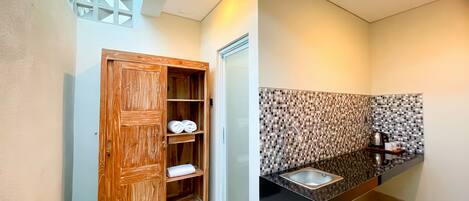 A modern bathroom with a wooden wardrobe, a tiled backsplash, and a black countertop.
