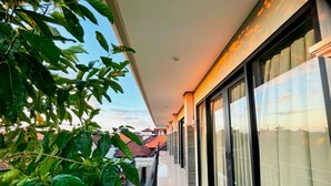 A balcony with a view of the sky and neighboring buildings. - Sekar Tunjung Guest House Seminyak (Denpasar)
