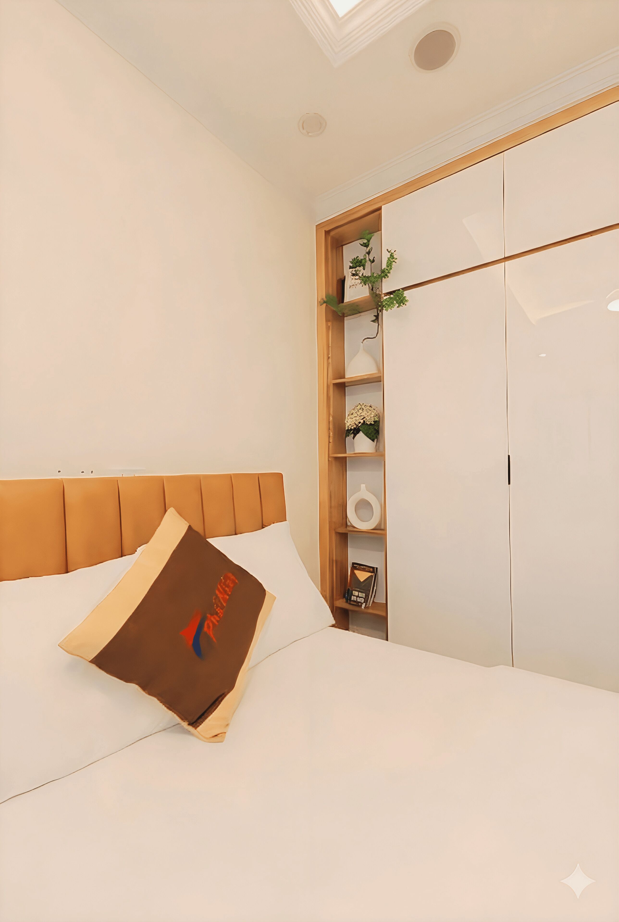 A bedroom with a bed, a wooden headboard, a bedside shelf with decorative items, and a wardrobe.