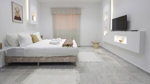 Une chambre moderne avec un lit, des tables de chevet, un téléviseur et une fenêtre avec des rideaux.