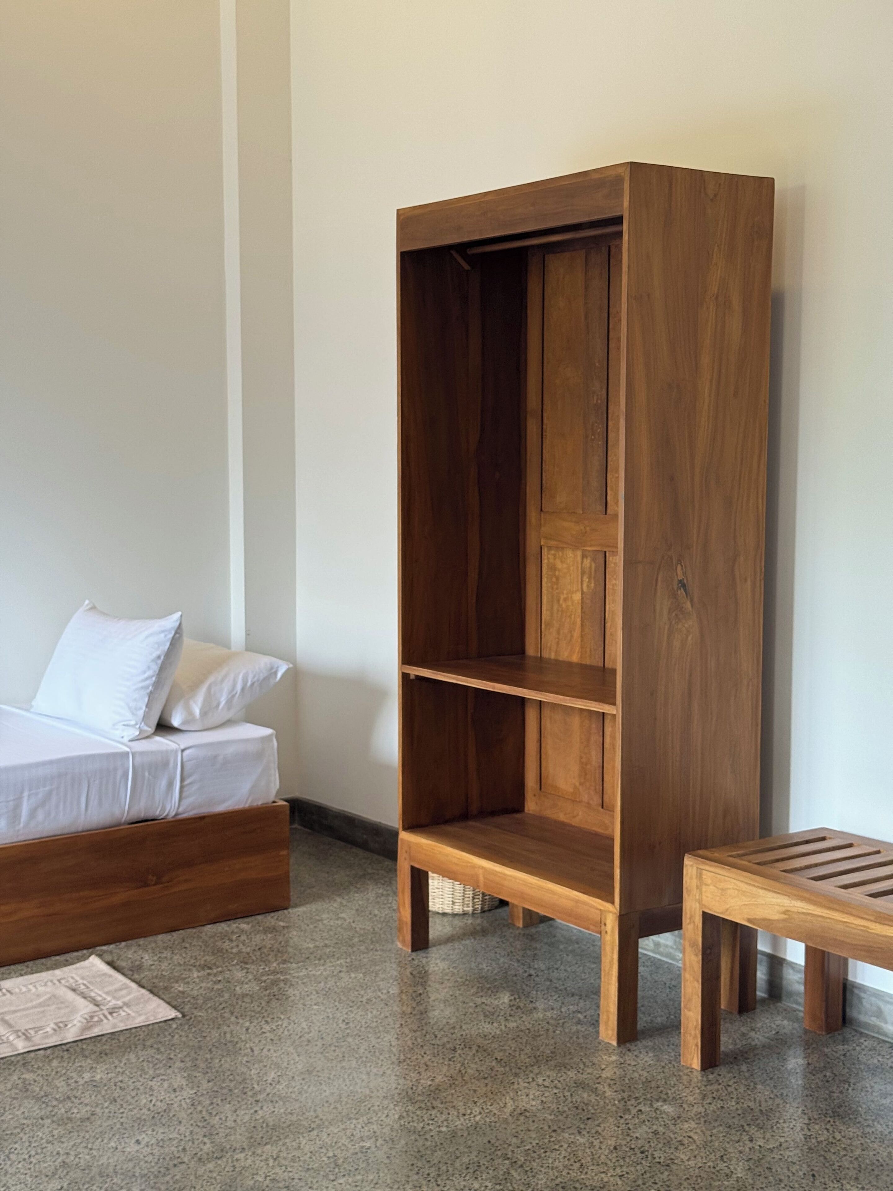 Ein Schlafzimmer mit einem hölzernen Bett, einem Holzschrank und einem kleinen Holztisch.