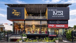 A building with multiple businesses including 'The Basisha's Pride', 'The Urban Deck Rooftop Restaurant', and 'Room's by DeVerveil'. - Rooms By DeVerveil (Mysore)