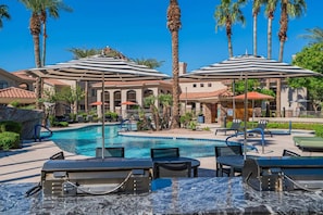 A pool area with lounge chairs, umbrellas, and palm trees. - Near Airport-Diablo Stadium-Pool-Spa-Gym-Parking (Tempe)