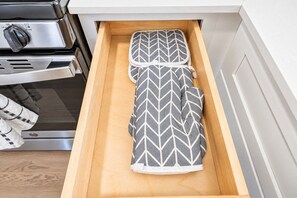 Un cajón de cocina con una toalla y un recipiente para utensilios.