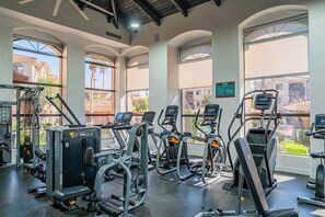 A gym with cardio machines, weight training equipment, and large windows offering views of the outside. - 2BR-2BA Near ASU & Arizona Mills | Pool & W/D (Tempe)