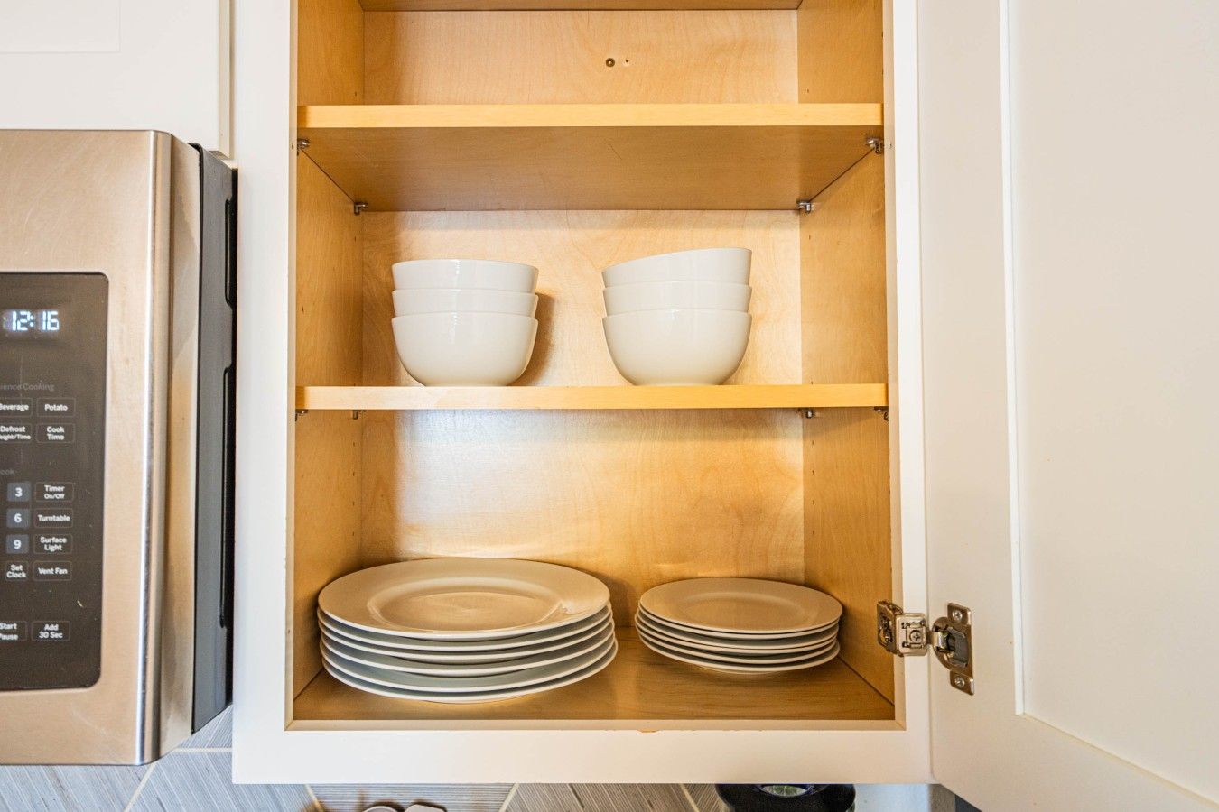 Ein Küchenschrank mit Regalen, voll mit Schüsseln und Tellern.