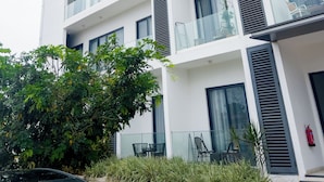 A multi-story building with balconies, large windows, and a fire extinguisher. - Cozy studio apt in Accra - Ghana with AC and gym access (Accra)