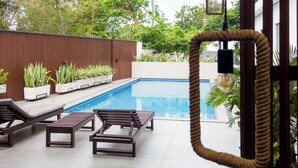 A pool area with wooden loungers and a pergola overhead. - Cozy studio apt in Accra - Ghana with AC and gym access (Accra)