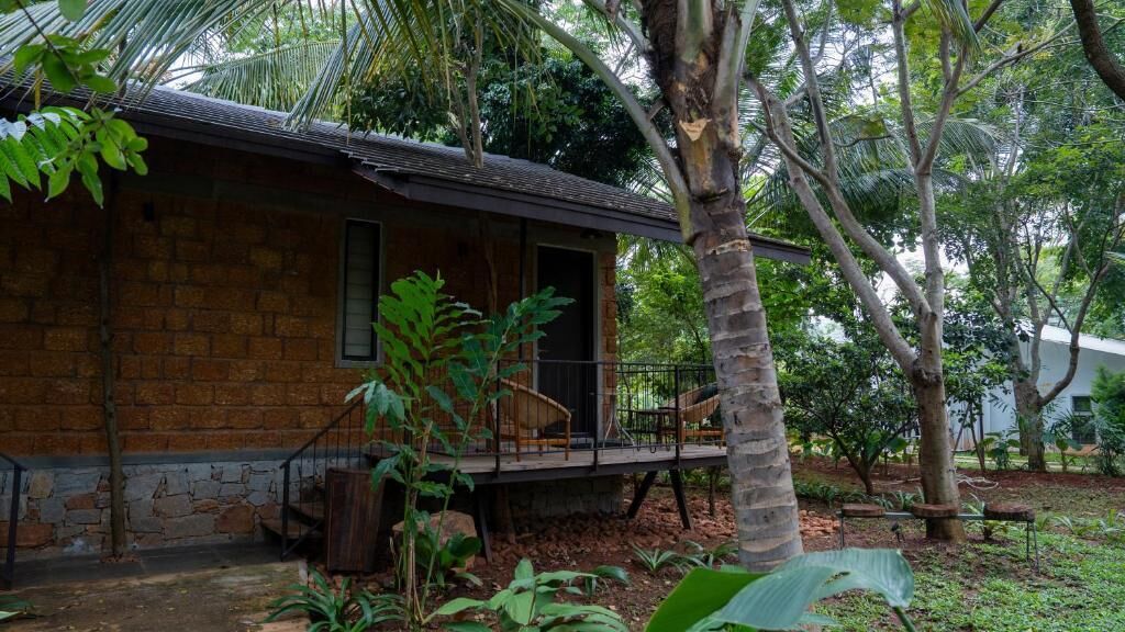 A rustic stone building with a wooden deck and a single door.