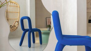 Un intérieur moderne avec deux chaises bleues, un fauteuil en osier et un comptoir vert.