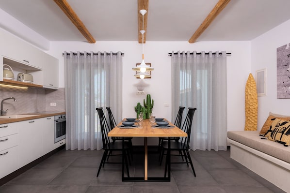 Une cuisine moderne avec des armoires blanches, un plan de travail en bois et un four encastré.