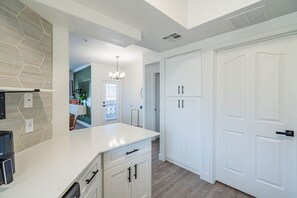 A modern kitchen with white cabinetry, a built-in island, and a stone backsplash. - Tempe Apartment near Airport & Stadium | Pool, Gym (Tempe)