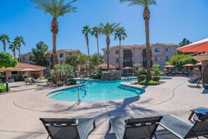 A pool area with lounge chairs, palm trees, and a building with multiple balconies. - Close ASU&Diablo Stadium - GymHotTubParkingPool (Tempe)
