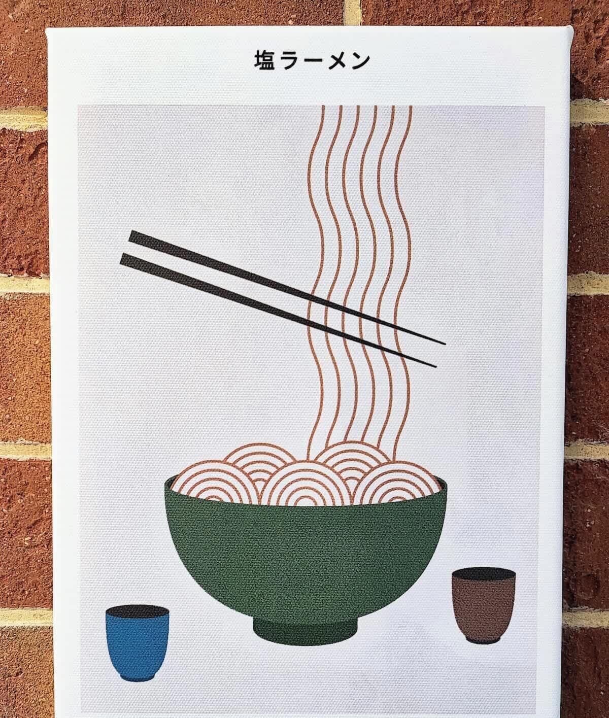 Een Japanse ramen-kom met stokjes die noedels optillen, met ernaast twee kleine bekertjes, en de tekst '塩ラーメン' bovenaan.