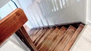 Una escalera de madera con una barandilla de vidrio en la parte superior.