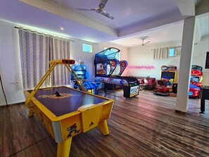 A room with a foosball table, arcade games, and a sofa. - Turban Aarambagh Resort and Spa (Kumbhalgarh)