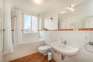 Un baño moderno con bañera, inodoro y lavabo.