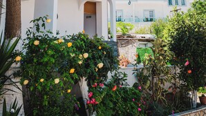 Un edificio moderno con un'area reception circondata da vegetazione lussureggiante e piante fiorite.