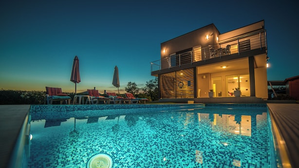 A modern two-story building with a swimming pool in the foreground. - Modern villa with pool, garden and sea view for 8 people in Istria (Galižana)