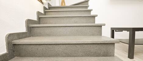 A staircase with a modern design, leading to a landing area with a flat surface.