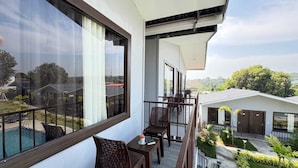 A balcony with a view of a swimming pool and a garden.