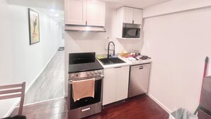 A compact kitchen with a stove, oven, sink, and microwave. - Delightful Studio in Montréal perfect for your city getaway (Montréal)