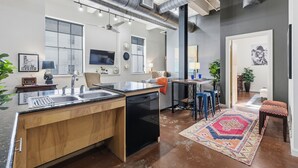 Une cuisine moderne dotée d’un îlot central, d’appareils électroménagers intégrés et d’une grande fenêtre.