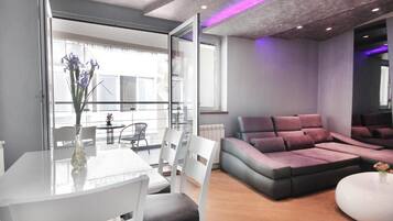 Appartement supérieur, balcon, vue sur la ville | Aire de séjour | Téléviseur