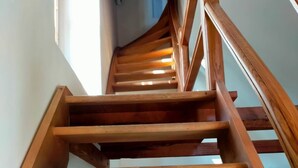 A wooden staircase with a handrail, leading to an upper floor.